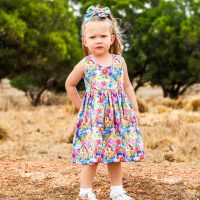Our Model Kenzie is wearing our bright rainbow floral action back tea party dress, Handmade Babies and Kids Clothing.